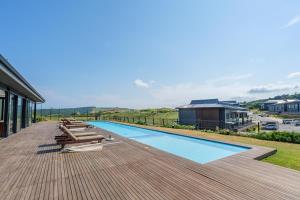 a deck with lounge chairs and a swimming pool at Vista Zimbali in Ballito