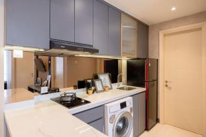 a kitchen with a washer and a stove top oven at Amalea at Benson Pakuwon Mall in Surabaya +87 photos