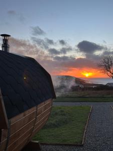 a sunset behind a building with the sun in the background at Seaview Retreat - Sauna & Ice Bath in Clonakilty +66 photos