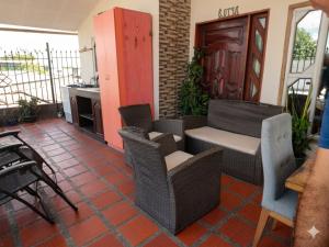 an outdoor patio with wicker chairs and a table at Apartaestudio amoblado Aeropuerto PIMSA bombona in Malambo