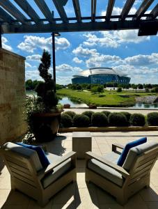 a patio with two chairs and a view of a building at Live! by Loews - Arlington, TX in Arlington
