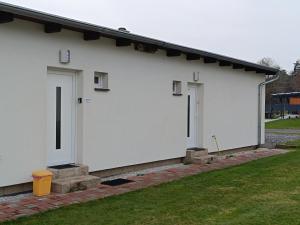 a white building with two doors on the side at Apartmán Velký Luh in Velký Luh