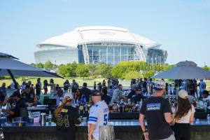 a group of people standing around a table in front of a building at Live! by Loews - Arlington, TX in Arlington +115 photos
