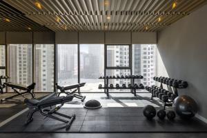 a gym with rows of exercise equipment and a large window at Near Dubai Mall PoolAccess SunSetView KingBed in Dubai