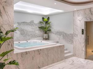 a bathroom with a tub with a plant in it at Near Dubai Mall PoolAccess SunSetView KingBed in Dubai