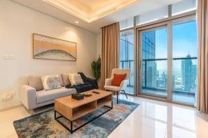 a living room with a couch and a table at Near Dubai Mall PoolAccess SunSetView KingBed in Dubai