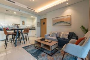 a living room with a couch and a table at Near Dubai Mall PoolAccess SunSetView KingBed in Dubai