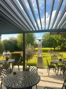 a patio with tables and chairs and a large window at The Stag in Salhouse