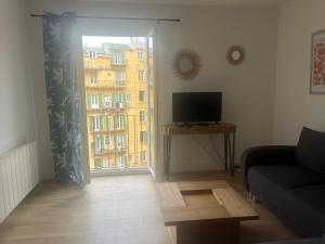 a living room with a couch and a television and a window at Appartement climatisé centre-Ville in Bastia