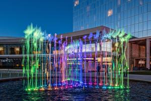 a fountain with colorful lights in front of a building at Live! by Loews - Arlington, TX in Arlington