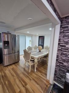 a dining room with a table and a refrigerator at Berwyn Alimot Proshortlet-home LLC in Syracuse