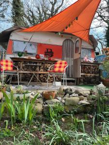 a caravan with an orange roof and two chairs and a table at Tinyhaus am Flughafen, der DLR und ESA in Cologne