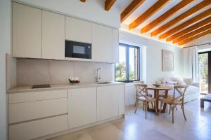 a kitchen with white cabinets and a table with chairs at Agroturisme Vistalegre Nou in Manacor