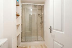 a shower with a glass door in a bathroom at Quiet Three-Bedroom Home in Stewartby with Ensuite and Workspace in Bedford