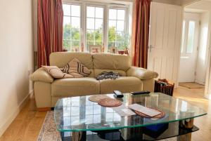 a living room with a couch and a glass table at Quiet Three-Bedroom Home in Stewartby with Ensuite and Workspace in Bedford +4 photos