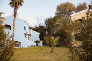 a white house with palm trees in the yard at Dreamy Seaside Loft Pool, Parking, Fast Wifi in Gouvia