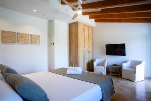 a bedroom with a large white bed and a tv at Agroturisme Vistalegre Nou in Manacor