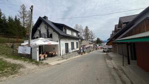 a house with an umbrella on the side of a street at Pokoje nad Jeziorem Solina in Solina