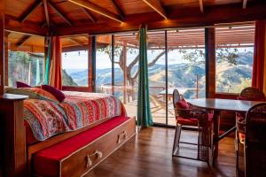 a bedroom with a bed and a table and some windows at El Sol Monteverde in Monteverde Costa Rica +142 photos