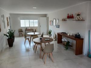 a living room with two tables and chairs and a kitchen at COLOFT - Quarto 4 Hospedagem rápida ou Sala de reunião in Anápolis