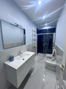a white bathroom with a sink and a toilet at Thalore room e apartments in Amantea