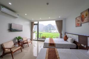a hotel room with two beds and a large window at Tam Coc Sunshine Villa in Vũ Lâm