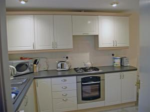 a kitchen with white cabinets and a microwave at 2 Bed in Birnam Dunkeld oc-ca266 in Birnam