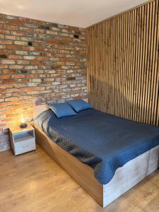 a bed in a room with a brick wall at Pensjonat pod Dębami in Pobierowo