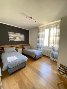 a room with two beds and a window at Residenza Basilica in Tirano