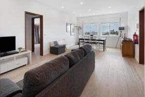 a living room with a couch and a dining room at Ocean City View Loft in Ponta Delgada