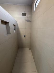 a bathroom with a walk in shower with white tiles at Casa Eucalipto in Chachagua