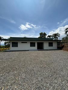 a white house with a gravel driveway at Casa Eucalipto in Chachagua