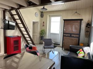 a living room with a couch and a table at Charmante maison vue chenal in Les Sables-d'Olonne