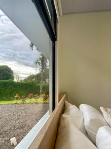 a bedroom with a window looking out at a garden at Casa Eucalipto in Chachagua +7 photos