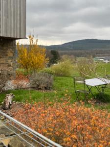 a bench sitting in a garden with flowers at ARD'n aise in Stoumont