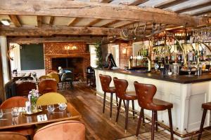 a bar in a restaurant with tables and chairs at The Stag in Salhouse