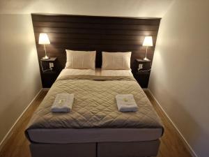 a bedroom with a large bed with two towels on it at Järnvägshotellet Charlottenberg in Charlottenberg