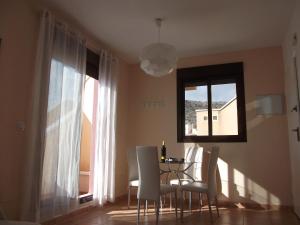 ein Esszimmer mit einem Tisch, Stühlen und einem Fenster in der Unterkunft Apartamento Relax in Águilas