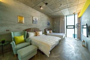 a bedroom with a bed and a couch and a chair at 蘆薈villa清水模派對k歌BBQ麻將包棟 in Wujie