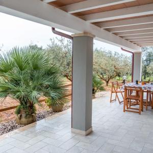 a patio with a table and a palm tree at Domo Appeddu in Orosei