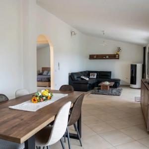 a kitchen and living room with a wooden table and chairs at Domo Appeddu in Orosei