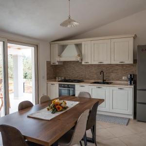 a kitchen with a wooden table with flowers on it at Domo Appeddu in Orosei +5 photos