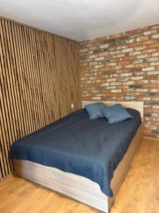 a bedroom with a bed and a brick wall at Pensjonat pod Dębami in Pobierowo +16 photos