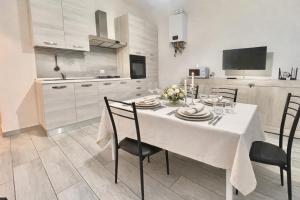 a dining room with a white table and chairs at Alloggio Nala 6 in Biella