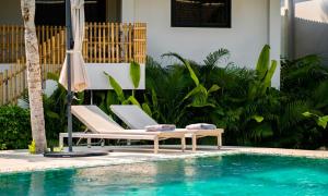 a pool with two chairs and an umbrella next to a swimming pool at Tulum Villa Resort Koh Samui in Bophut +148 photos