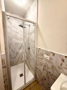 a shower with a glass door in a bathroom at B&B Il GLICINE - Uso Cucina e Parcheggio Privato in Sassuolo