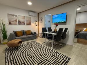 a living room with a dining table and a couch at Mobile home Mare Blu in Rovanjska