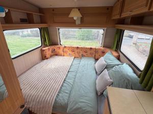 a bed in the back of a van with two windows at Camping im Lammgarten in Volkach