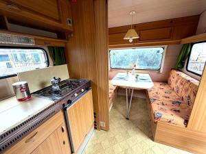 a kitchen in an rv with a sink and a stove at Camping im Lammgarten in Volkach