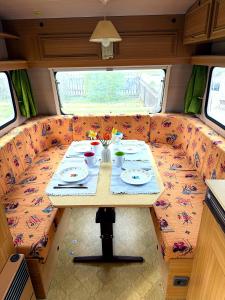 a table in the back of a campervan with a table and plates at Camping im Lammgarten in Volkach